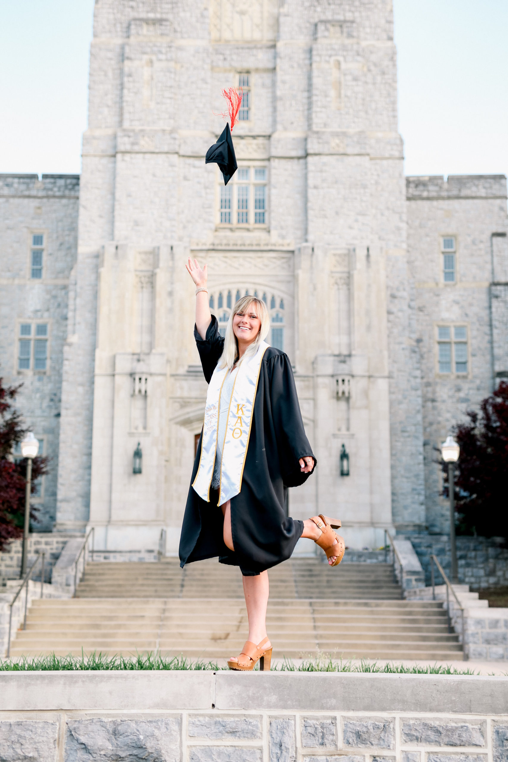 Senior Graduate tossing cap on Virginia Tech’s campus