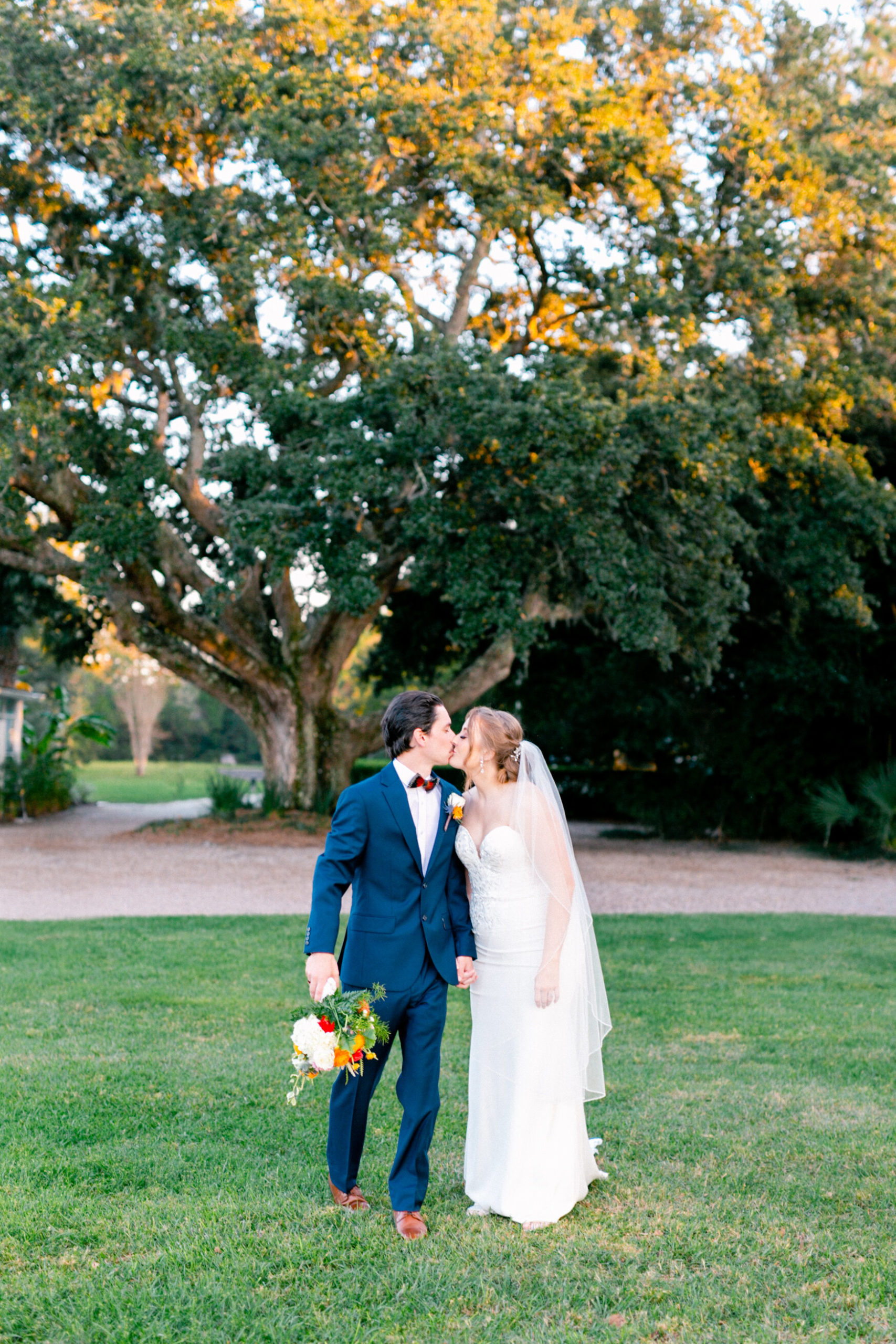 Southern couple share a sweet kiss under the Spanish moss in Charleston at their wedding.