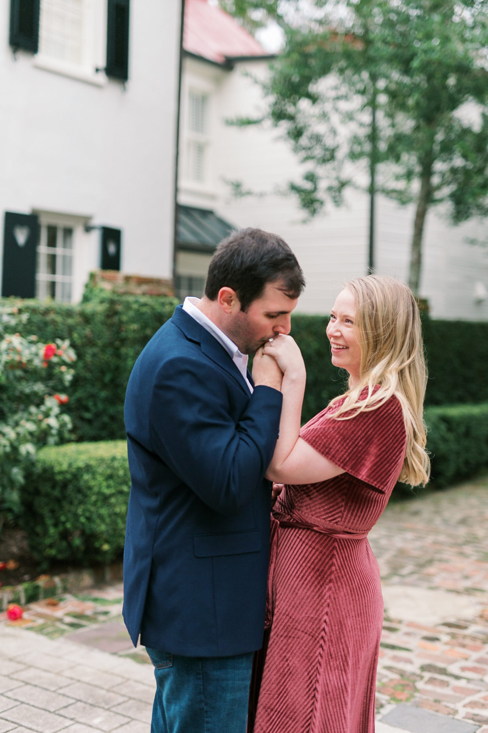 Sweet couple kissing in downtown Charleston historic streets for engagement session