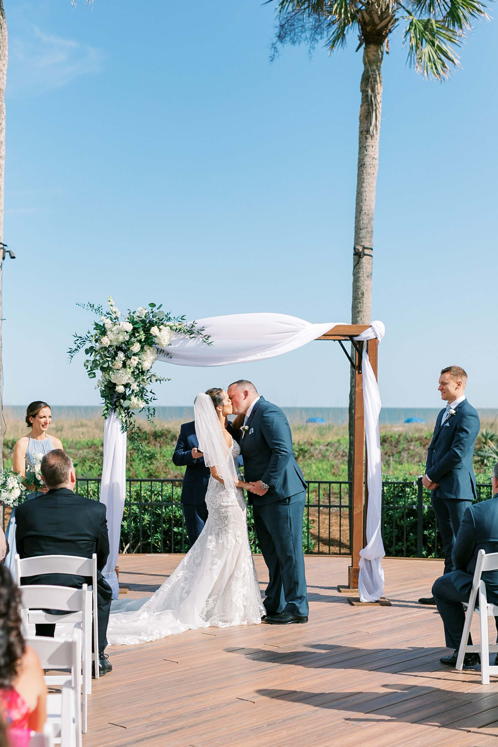 Joyful happy first kiss of bride and groom in Hilton Head Island, South Carolina beachside wedding.