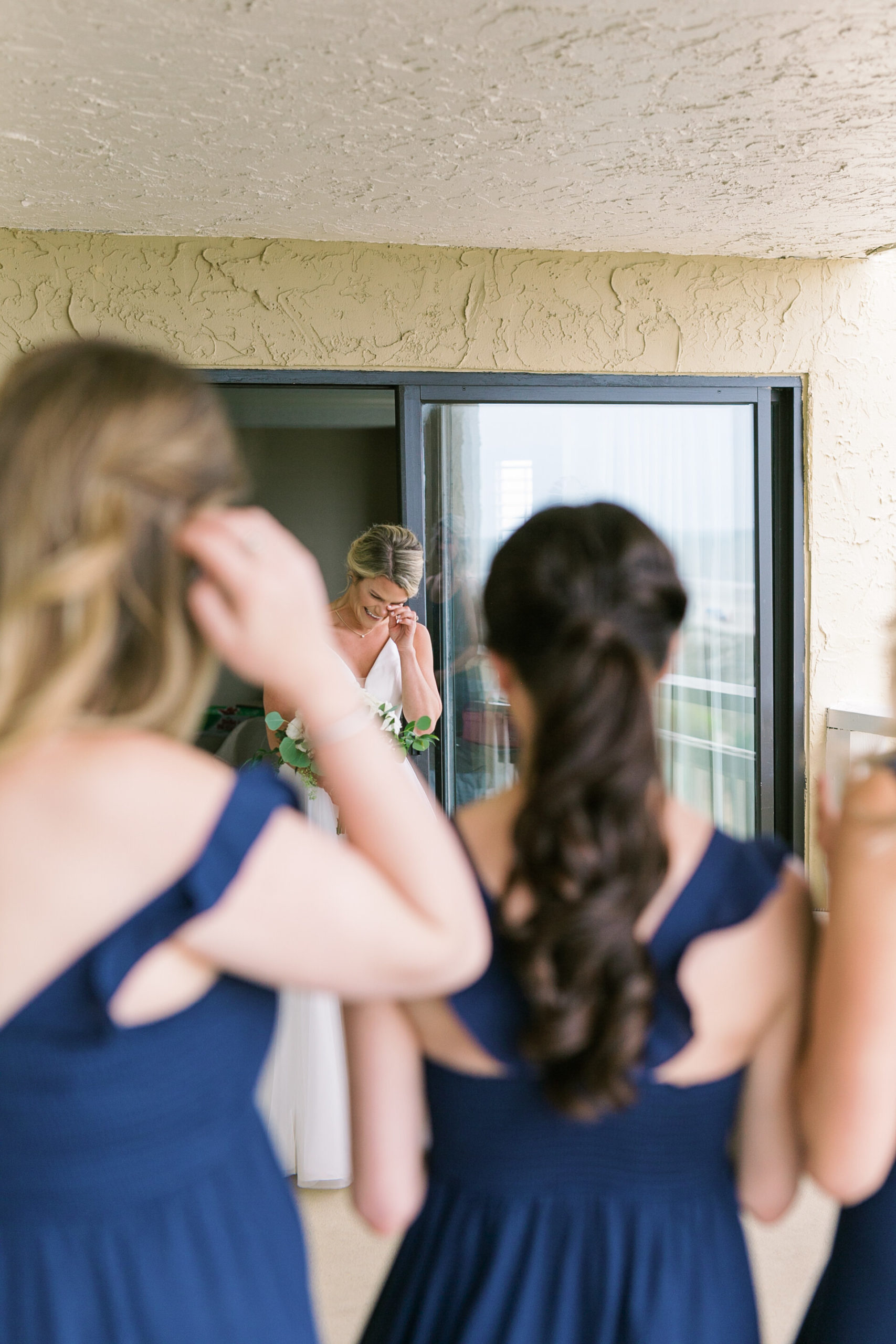 Tearful bride reacts to her dress reveal to her bridesmaids for her springtime beach wedding at the Omni Hilton Head Oceanfront Resort.