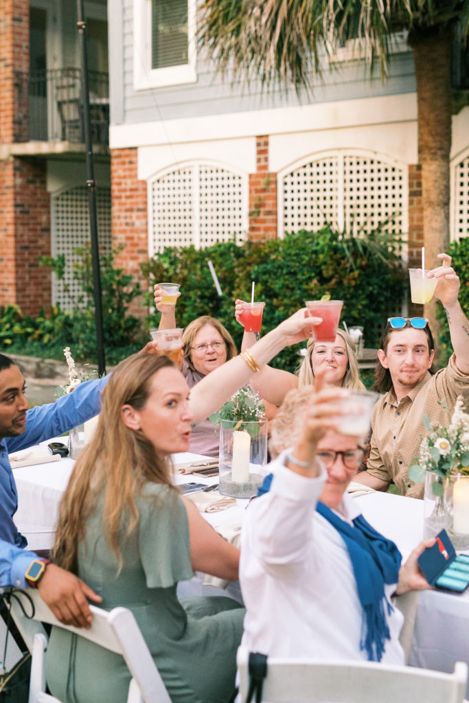 Wedding guest toasts to bride and groom at stylish Charleston wedding