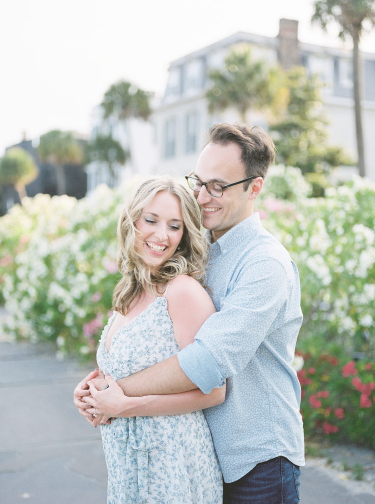 Engaged couple laughs on camera during beautiful Charleston engagement photos on film