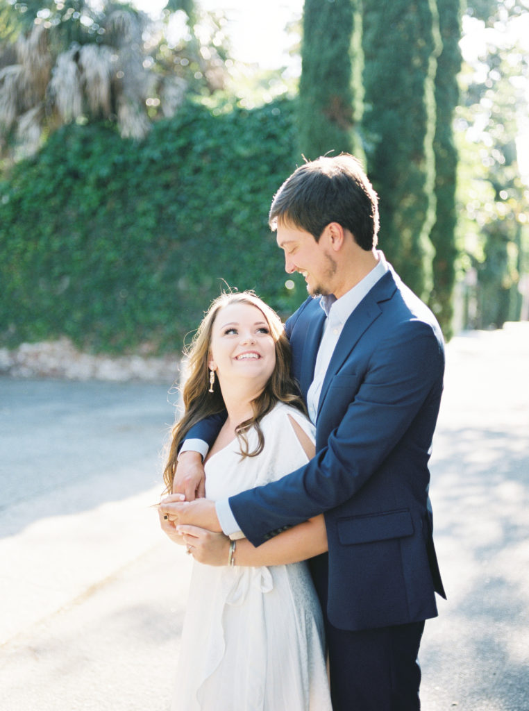 Engaged couple shares a hug on camera in historic Charleston engagement portrait session