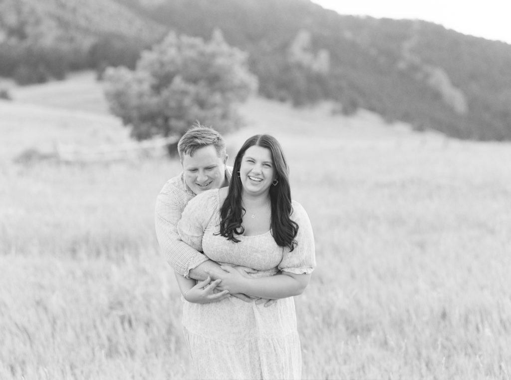Couple laughs on camera for Boulder engagement photos with a fine art Colorado wedding photographer