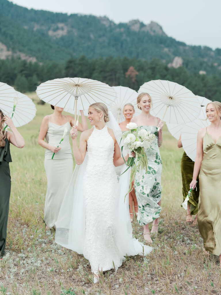 Bridesmaids in green dresses walk in Chautauqua Park