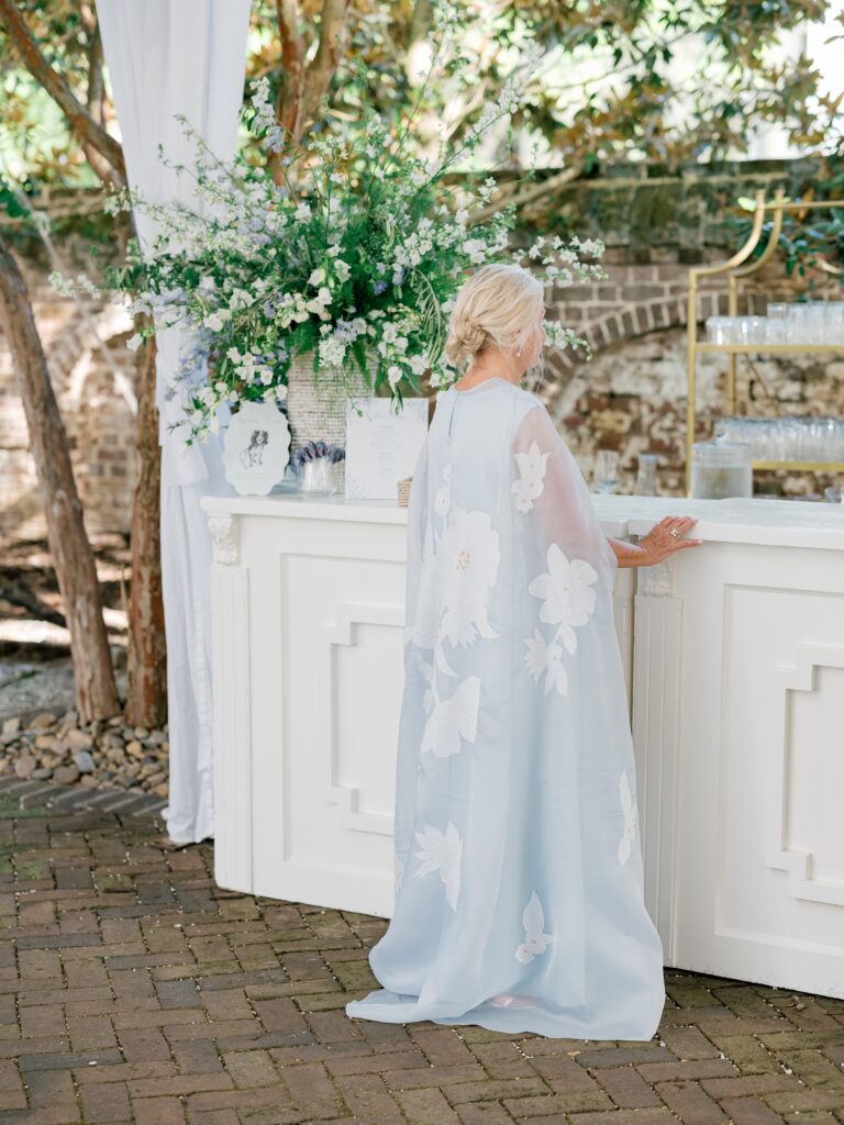 Guest stands at outdoor white bar at Charleston wedding reception