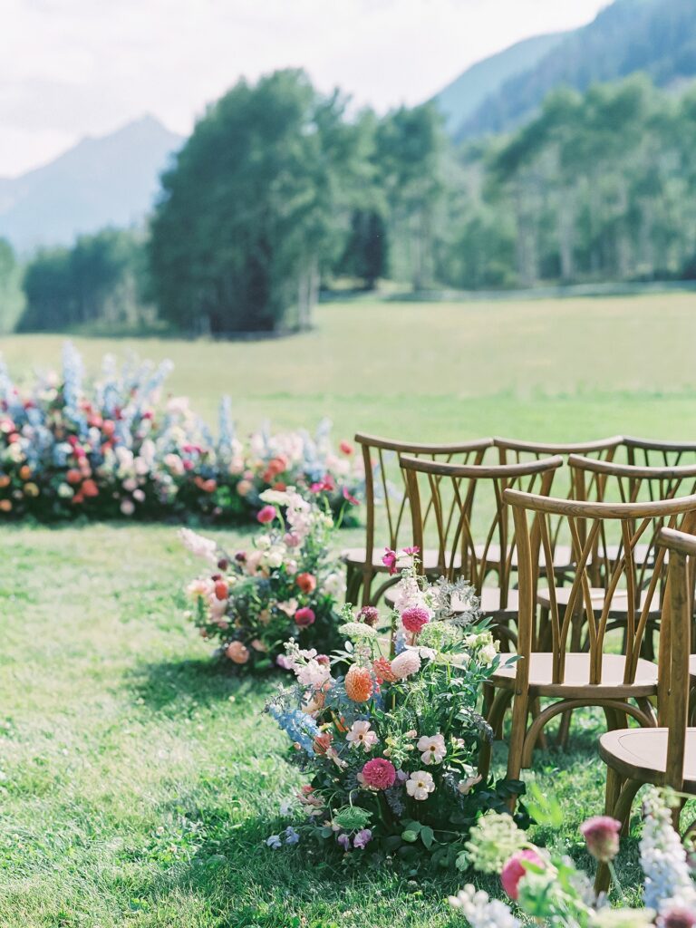 Vibrant, bountiful florals line the aisle at T Lazy 7 Ranch wedding