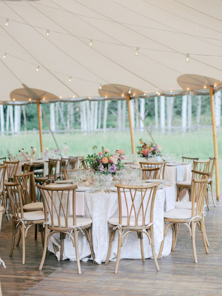 Wedding reception sailcloth tent with vibrant floral installations
