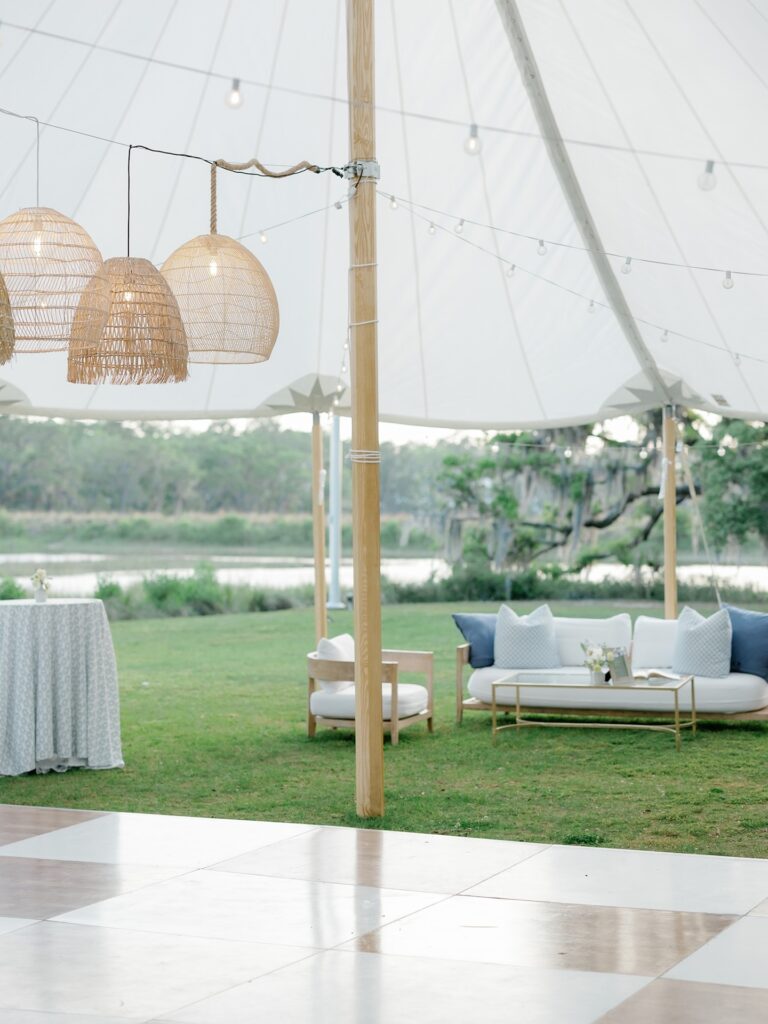 Sailcloth tent wedding reception at The Dunlin Kiawah River with modern lounge area, rattan lanterns, and a checkered dance floor.